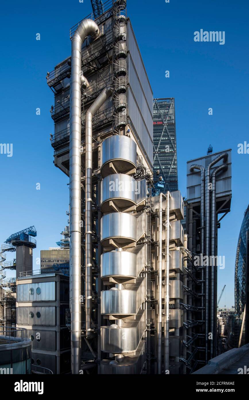 Stairwells and external pipe work with views of elevator towers, Leadenhall building in the background, the Gherkin edging into the right hand side. T Stock Photo