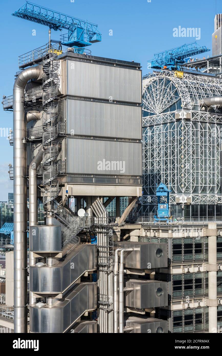 Elevated view of the elevator tower and atrium with blue cleaning cranes and spiral stairs. Lloyd's Building, London, United Kingdom. Architect: Roger Stock Photo