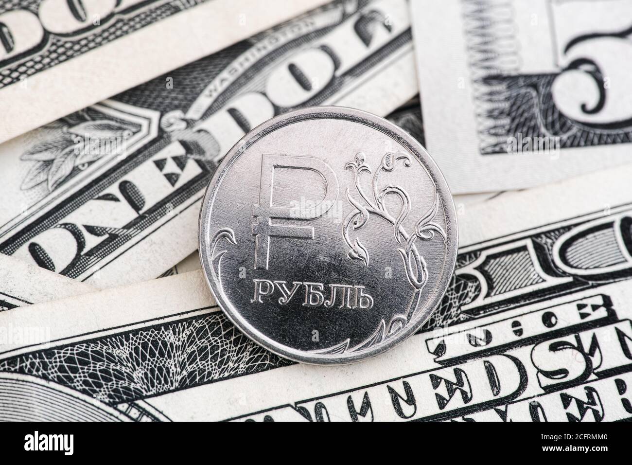 One russian ruble coin on american dollar bills. Close up. Stock Photo