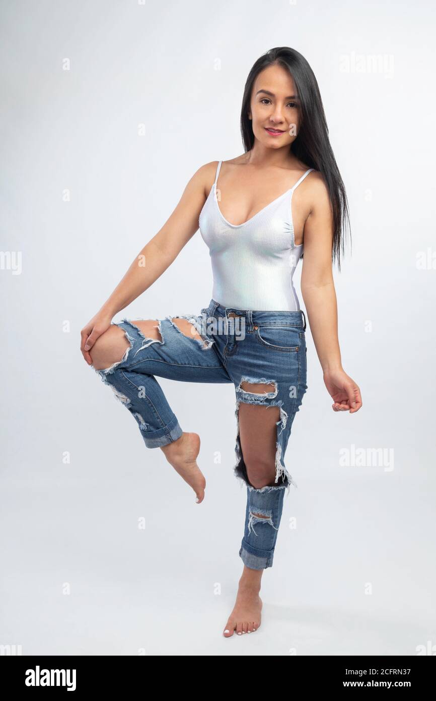 latina 14 years old  barefeet young slim woman in jeans and white bodysuit, latin girl on studio with  gray background Stock Photo - Alamy
