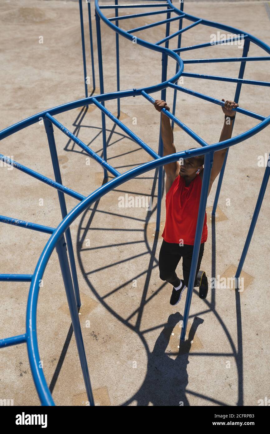 Man with prosthetic leg working out on monkey bars in the park Stock