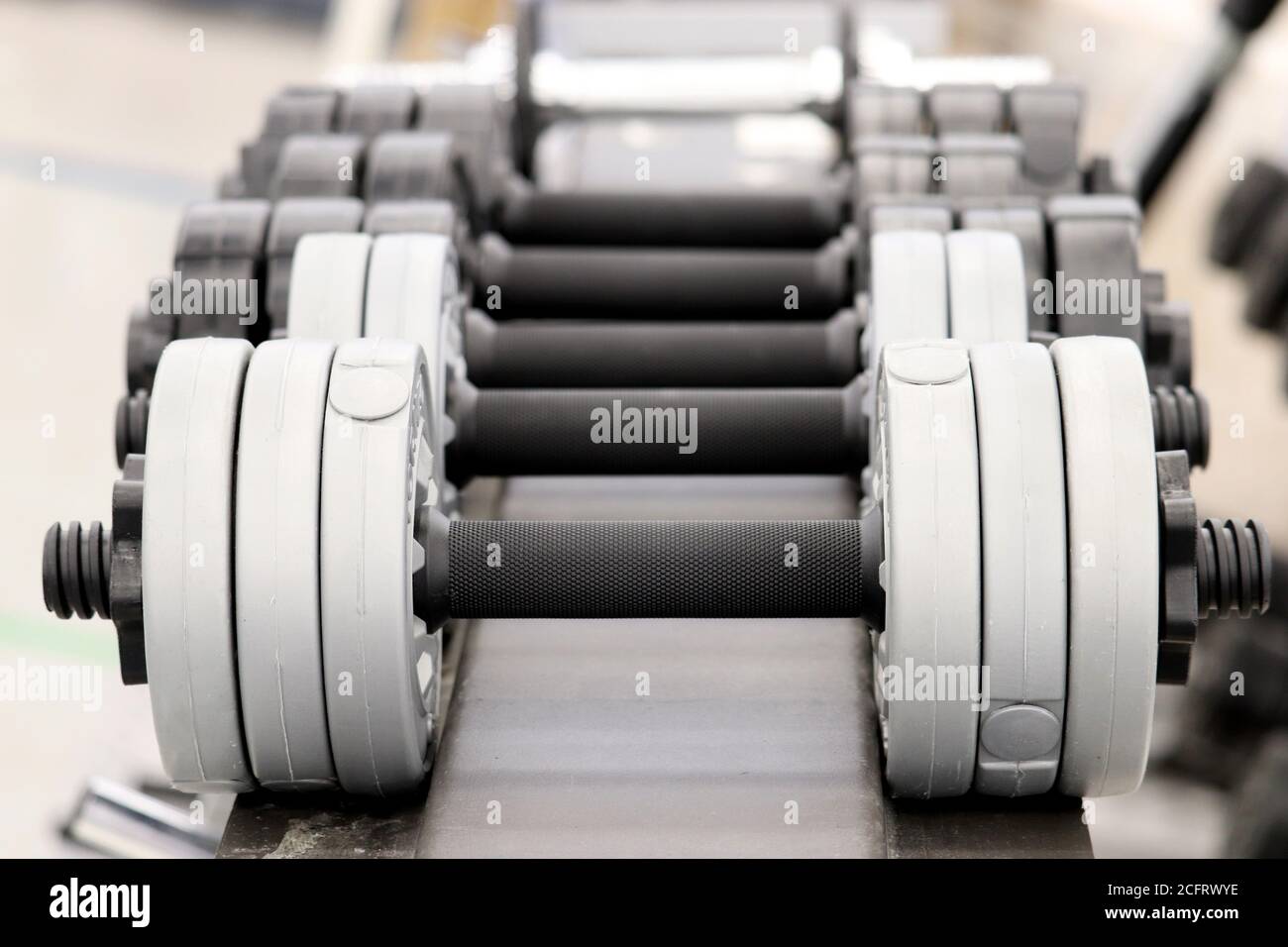 Dumbbells on rack in the gym, selective focus. Concept for weightlifting, bodybuilding, fitness center, sports Stock Photo