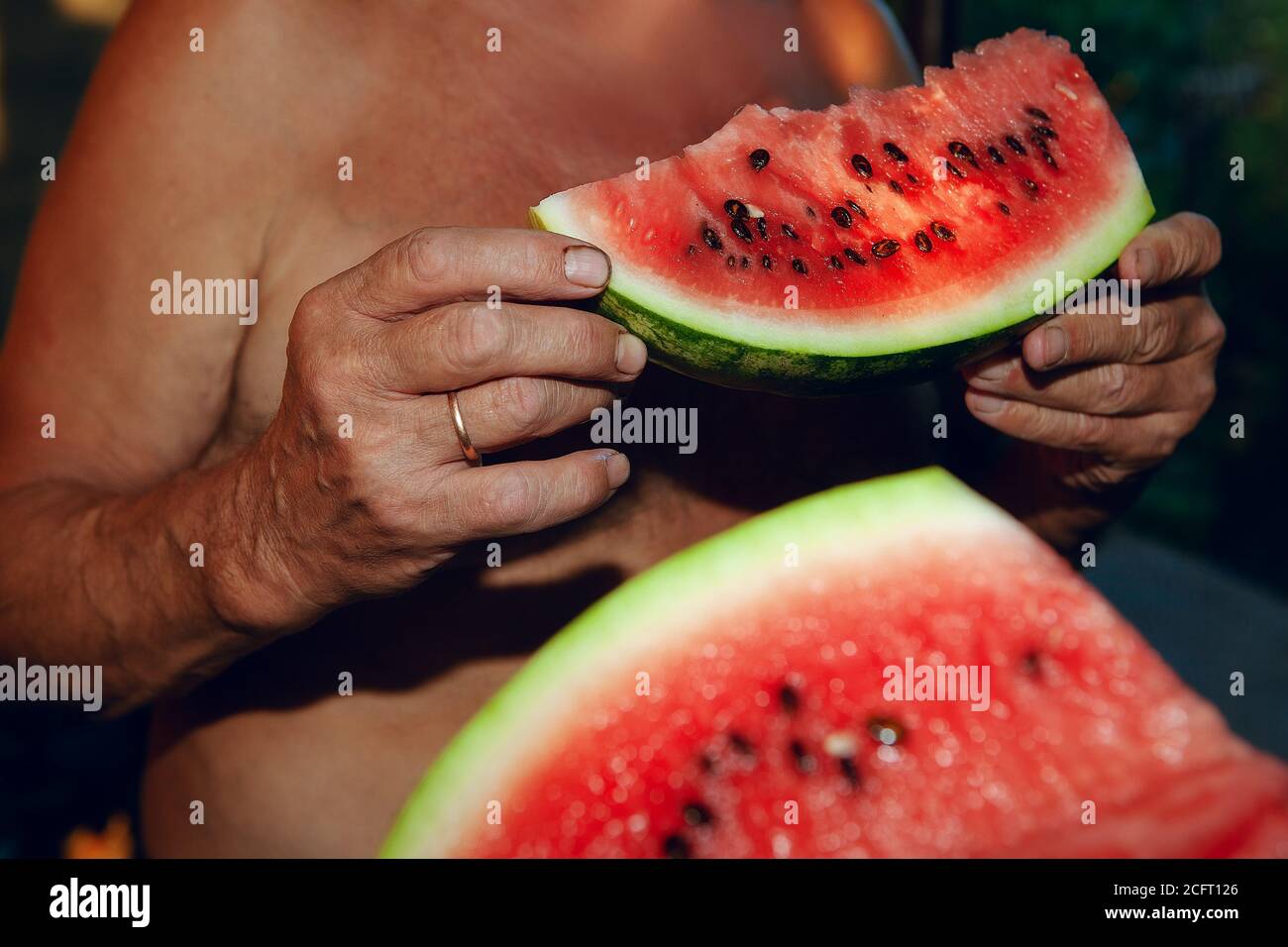 Man eating watermelon . Farmer holding watermelon in the hans ready to eat Stock Photo