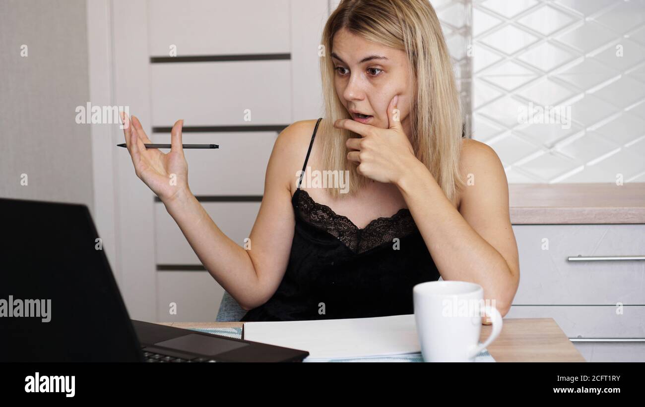 Portrait of an attractive woman at the table with cup and laptop ...