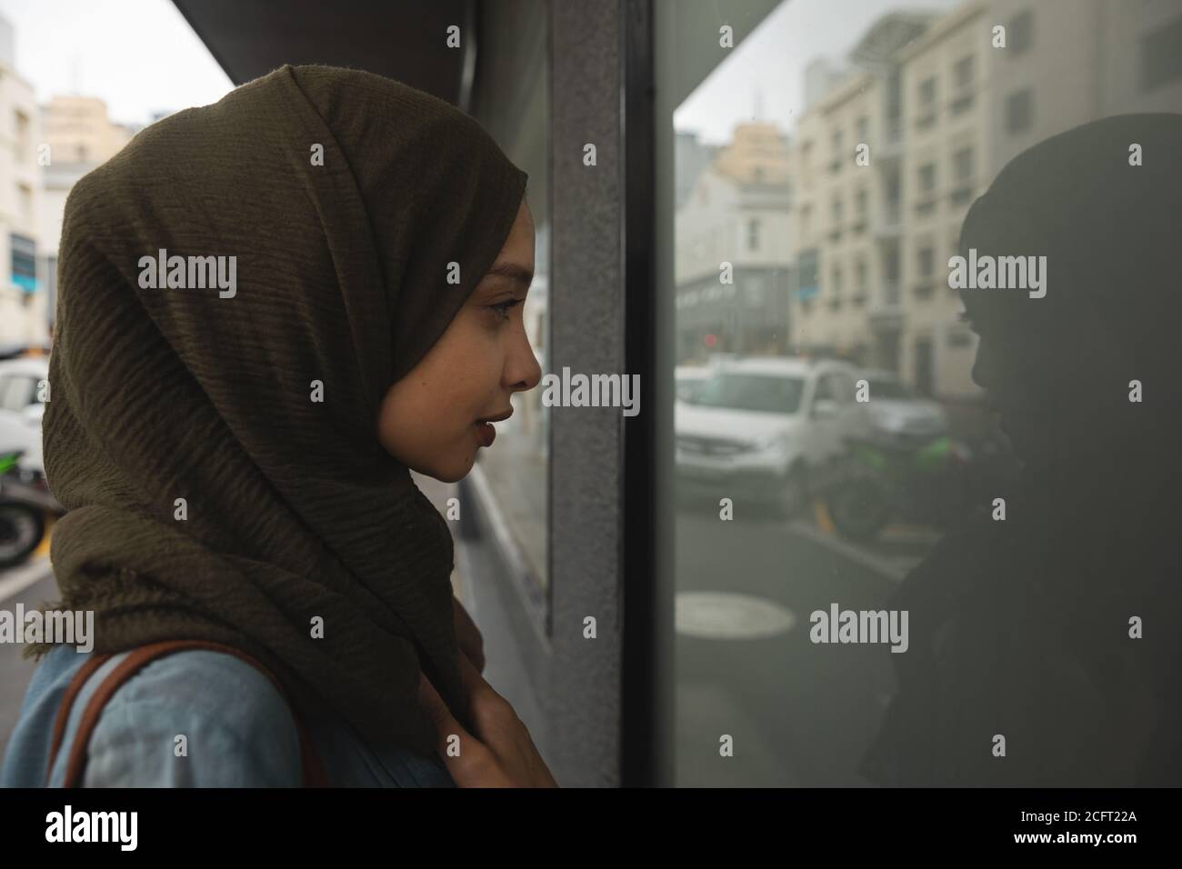 Woman in hijab looking through a shop window Stock Photo