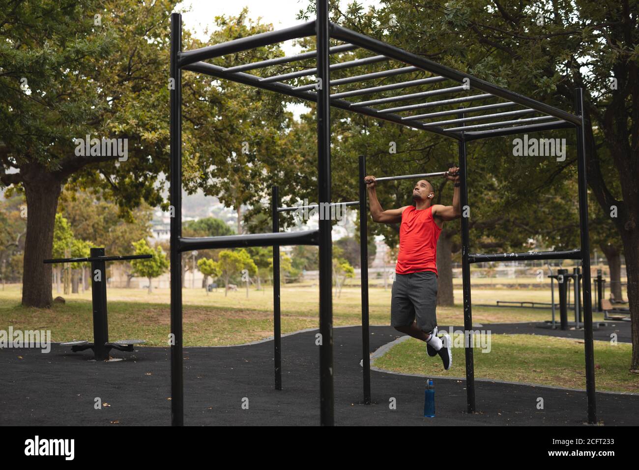 Man with prosthetic leg performing pull up exercise in the park Stock Photo