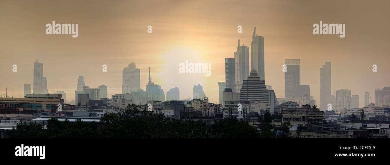 Bangkok at sunrise on eve of hot day. Even standard skyscrapers do not disturb humid tropical atmosphere city. Balance of traditional (bottom) and mod Stock Photo