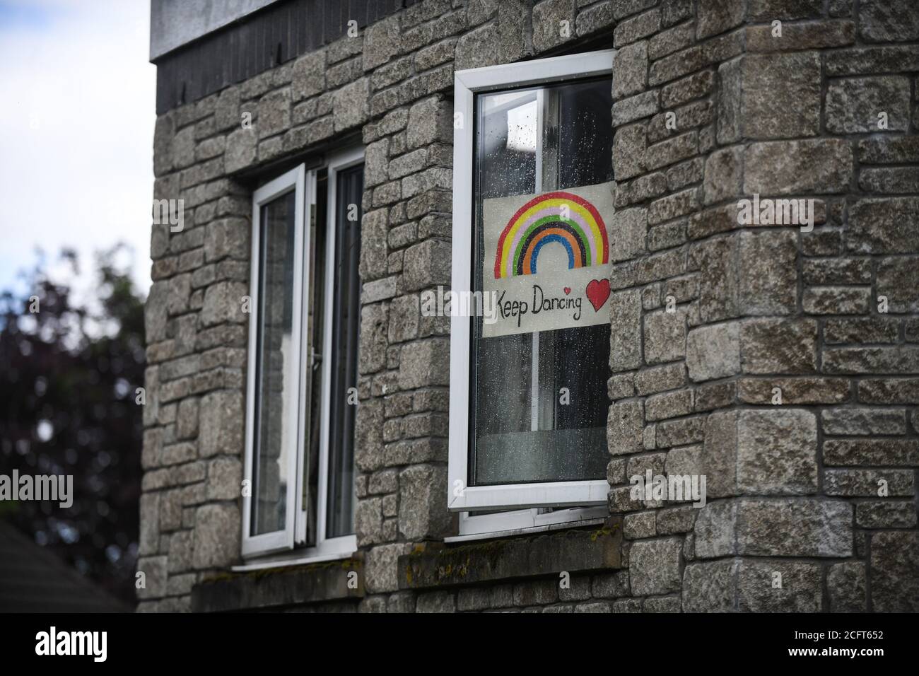 A rainbow sign in a window full of positive words during the coronavirus lockdown period in the UK. Households all over the country put signs in their Stock Photo