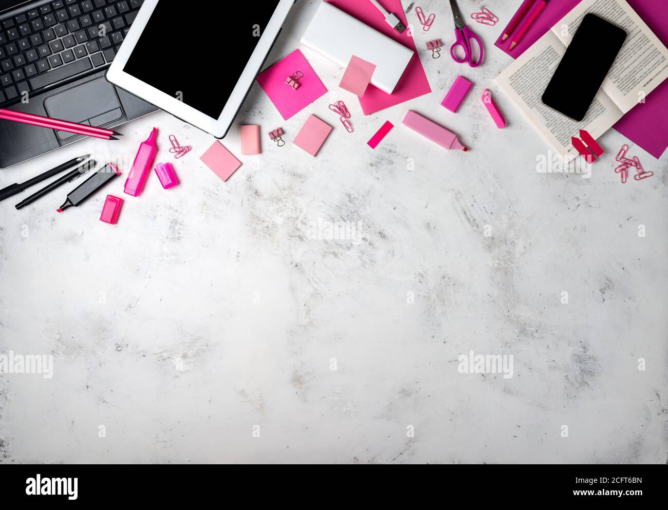 Female workspace with pink office accessories and gadgets. Top view