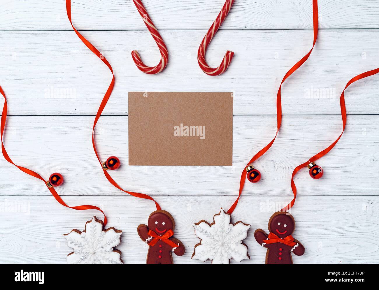 Winter festive background with gingerbread man and candy canes on white