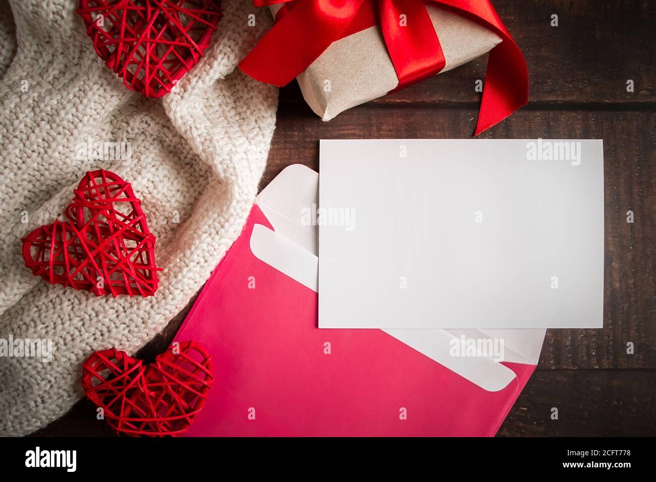 Envelope and greeting card on a wooden background. Blank postcard in a pink envelope on a wooden background. Layout for design for Valentine's Day Stock Photo