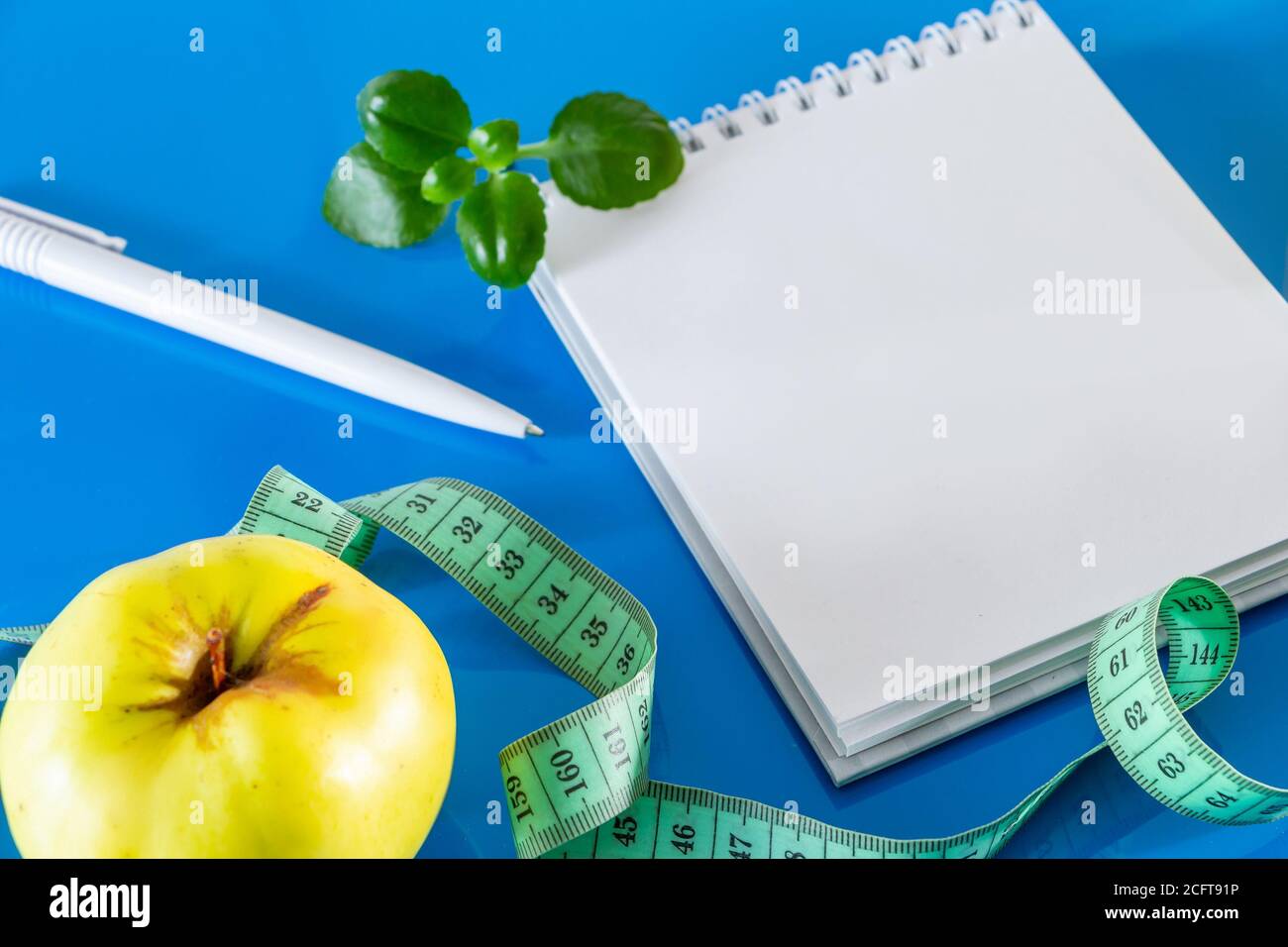 The concept of diet and proper nutrition. Fruits and measuring tape on a blue background.  Layout for design, healthy food and lifestyle. Quarantine E Stock Photo