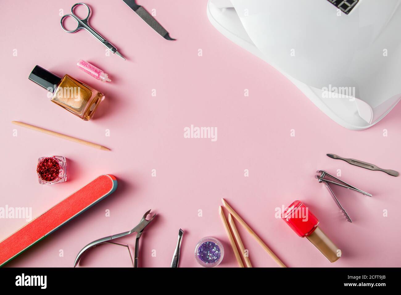 A set of tools for manicure and nail care on a pink background