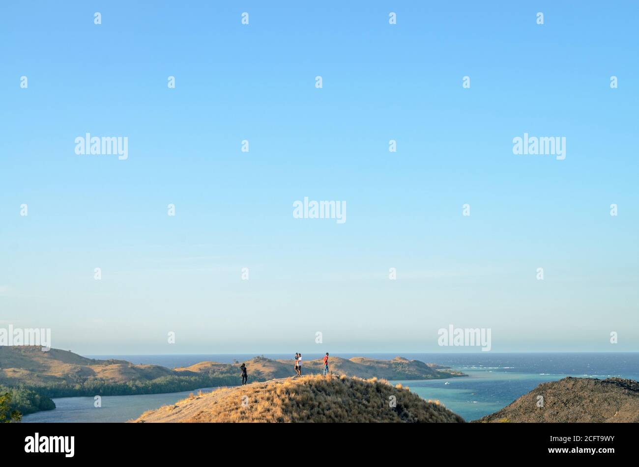 a tourists enjoying the view from the top of the Sylvia Hill, Labuan Bajo, Flores Island, East Nusa Tenggara, Indonesia Stock Photo