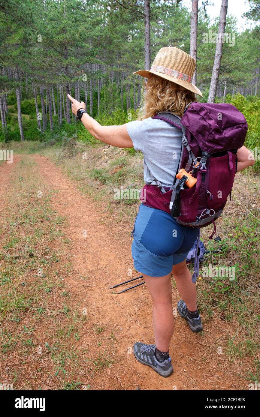 Hiker mature young woman with a hat  in a path. Stock Photo