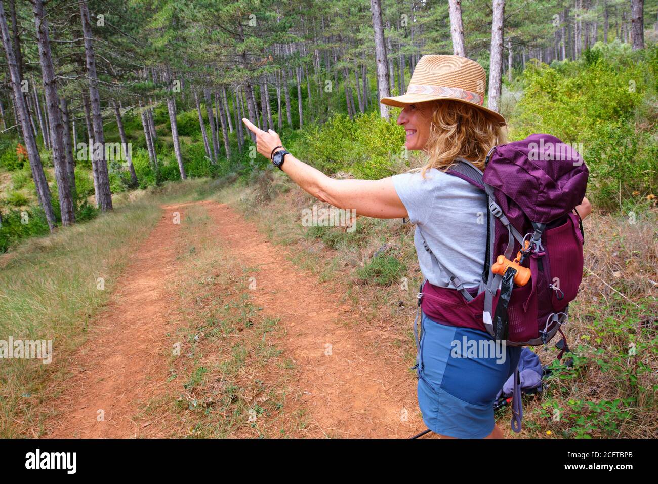Hiker mature young woman with a hat in a path Stock Photo - Alamy
