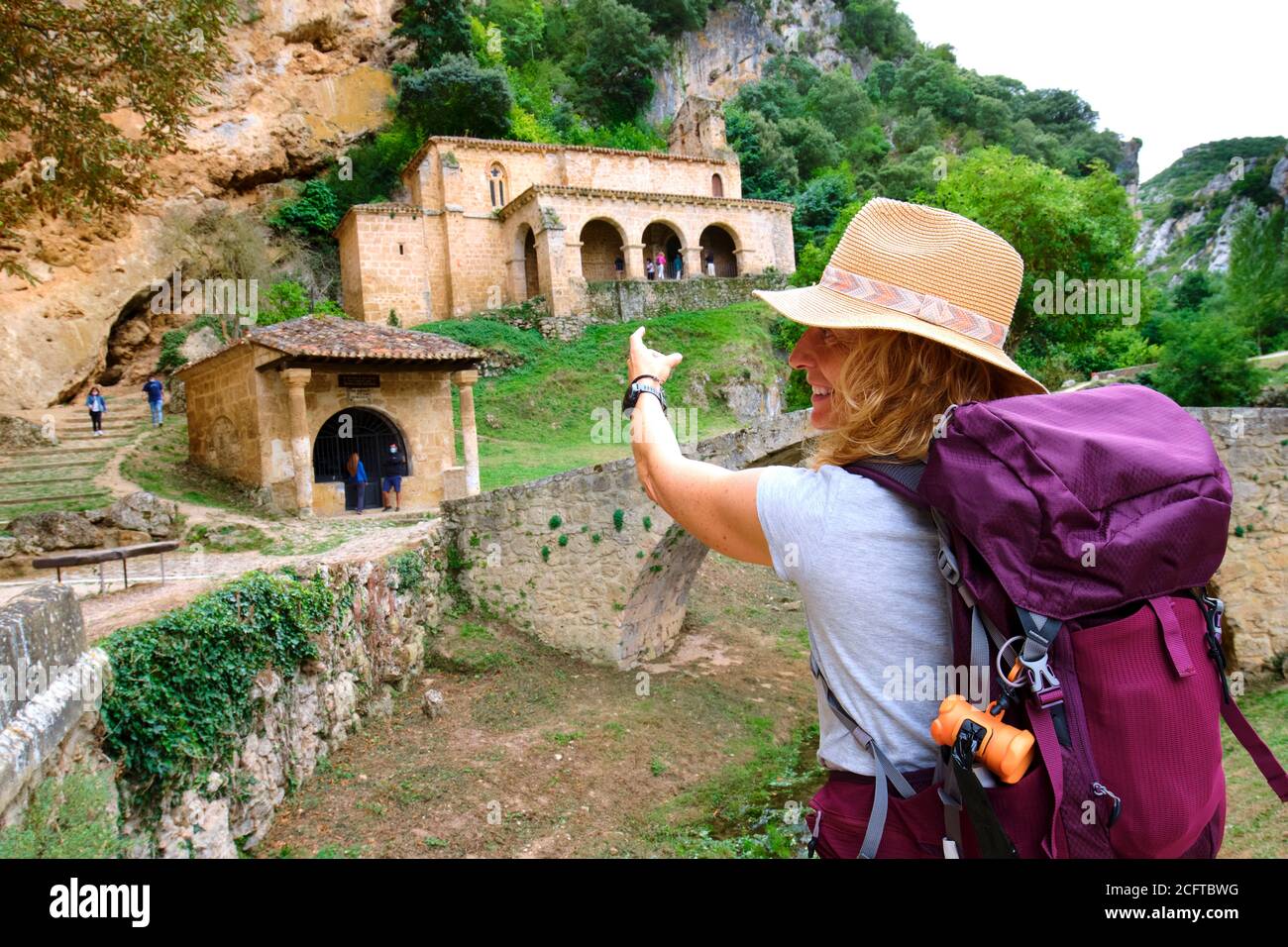 Hiker mature young woman close to an old chapel. Stock Photo
