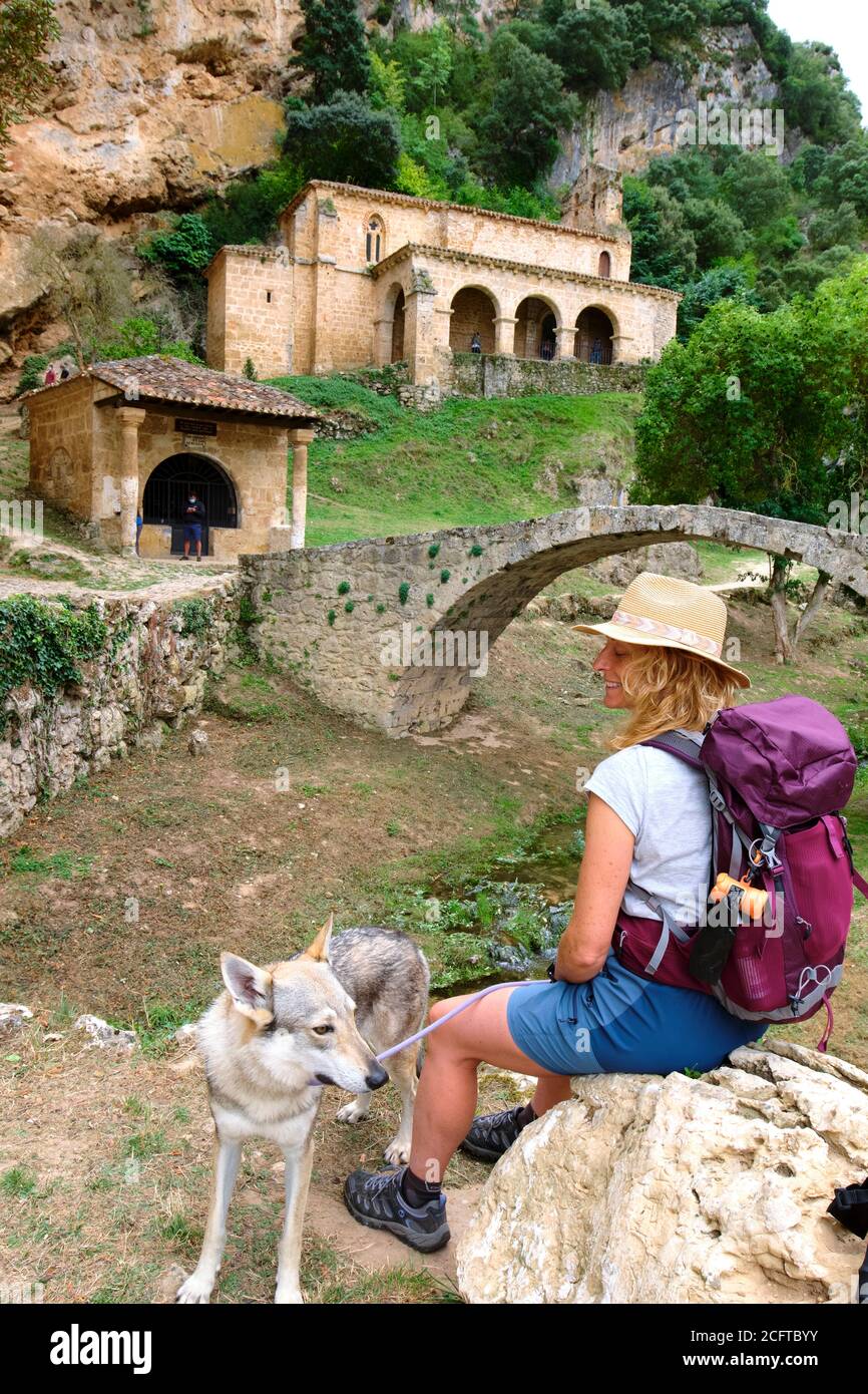 Hiker mature young woman and dog in Santa Maria de la Hoz chapel. Stock Photo