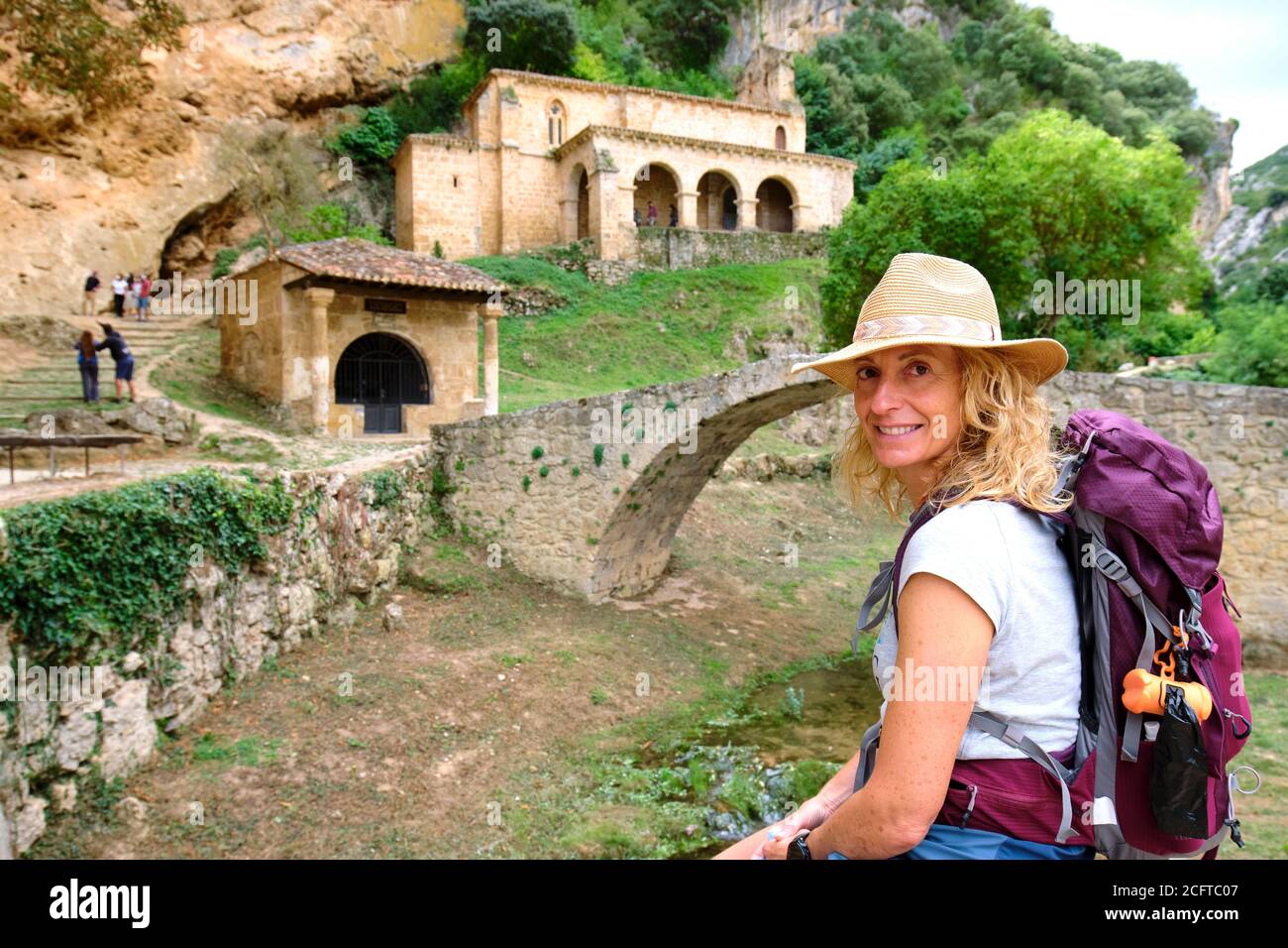 Hiker mature young woman close to an old chapel. Stock Photo