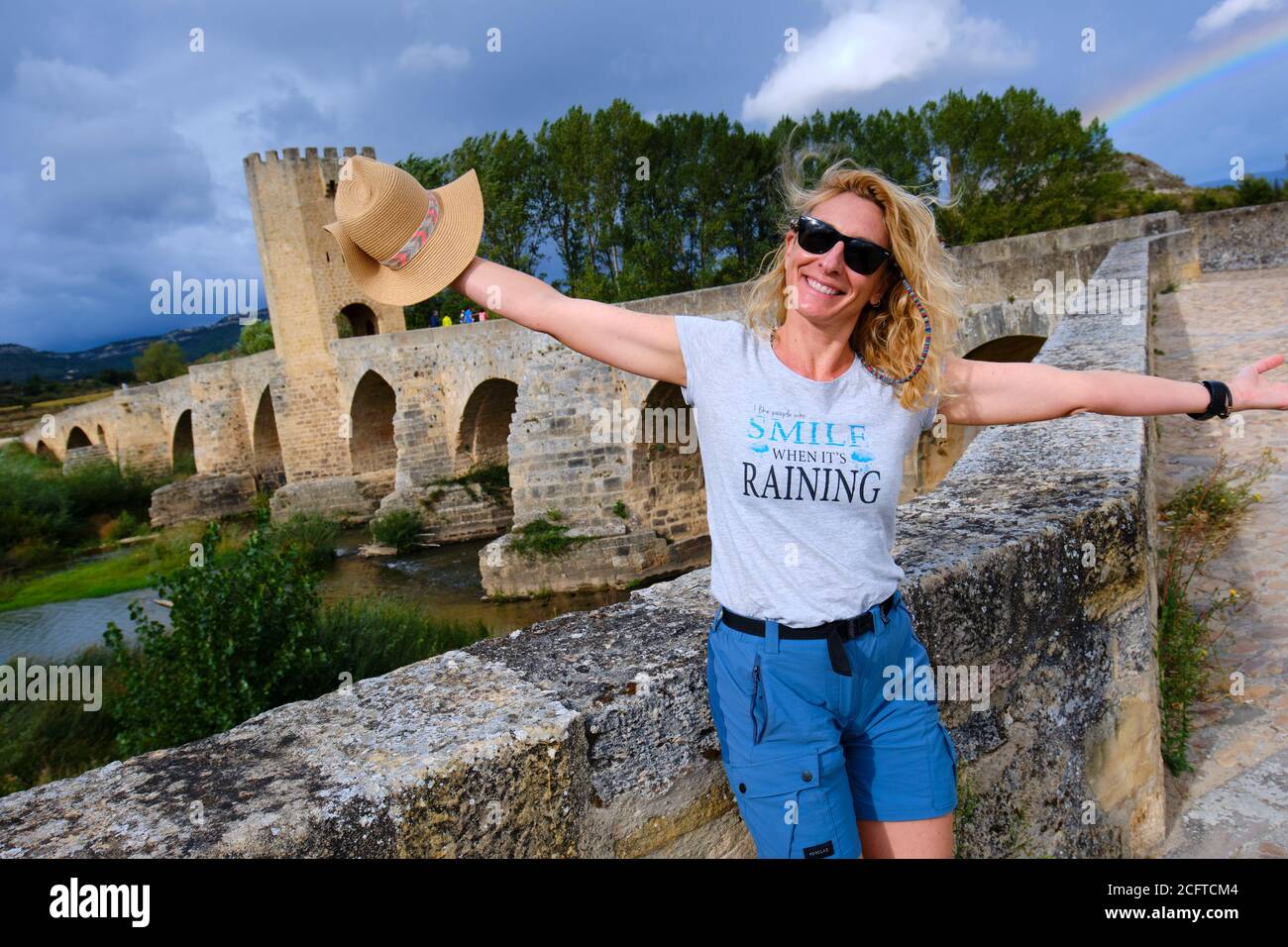 Tourist woman with a hat and medieval bridge and Ebro river. Stock Photo