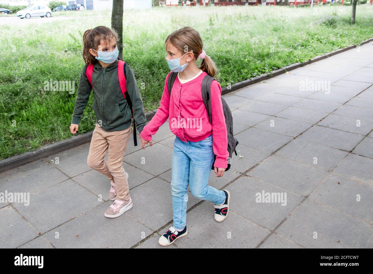 Two girls wearing protective face mask and going back to school during ...