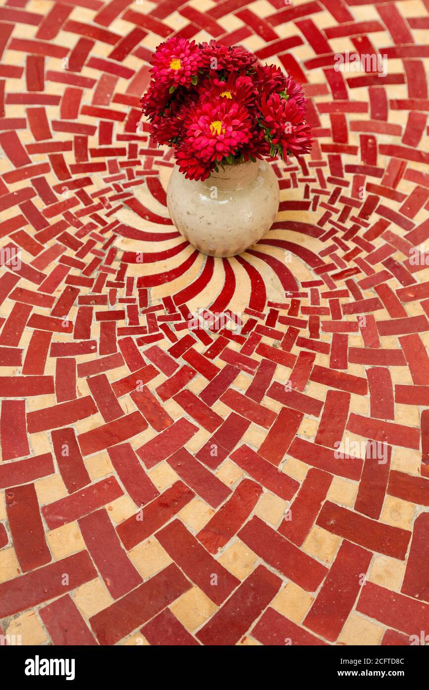 A vase of flowers on a Moroccan tiled table Stock Photo