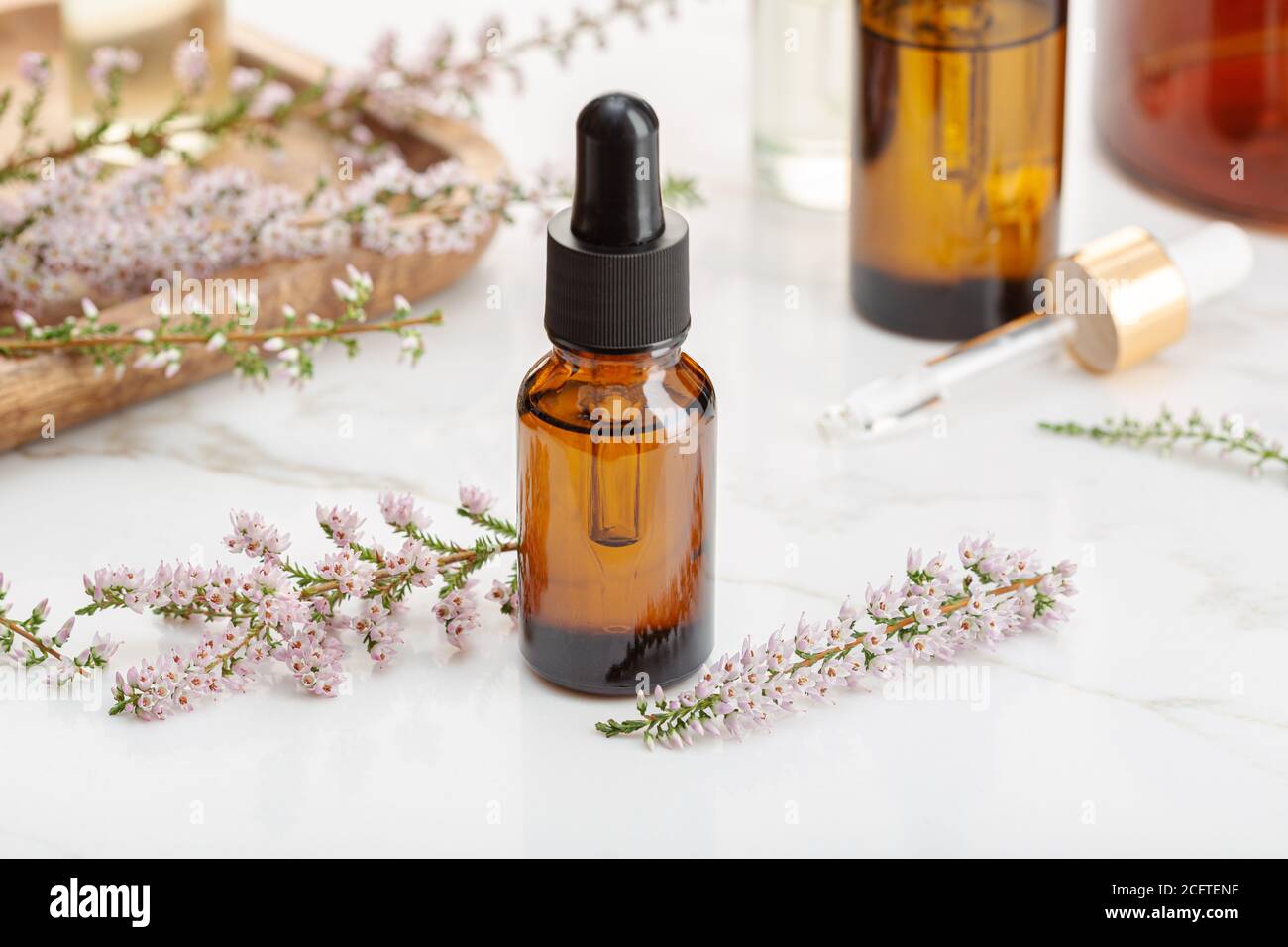 Heather essential oil on amber bottle still life. Herbal remedies Stock