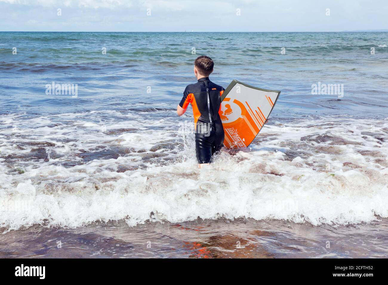 Eleven year old boy surfing at hope cove beach hires stock photography