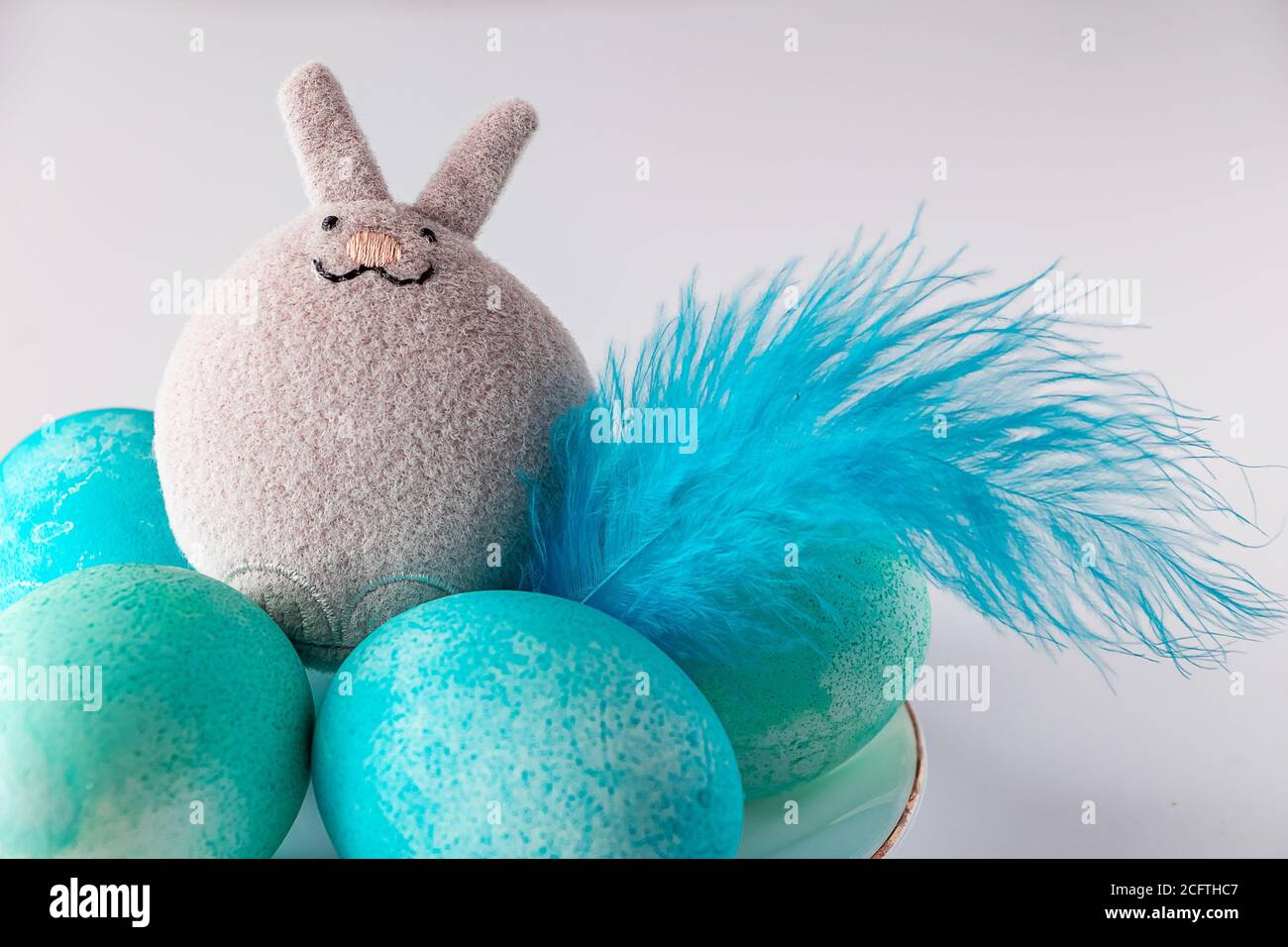 Blue easter eggs and toy rabbit on a white background. Cute toy easter ...