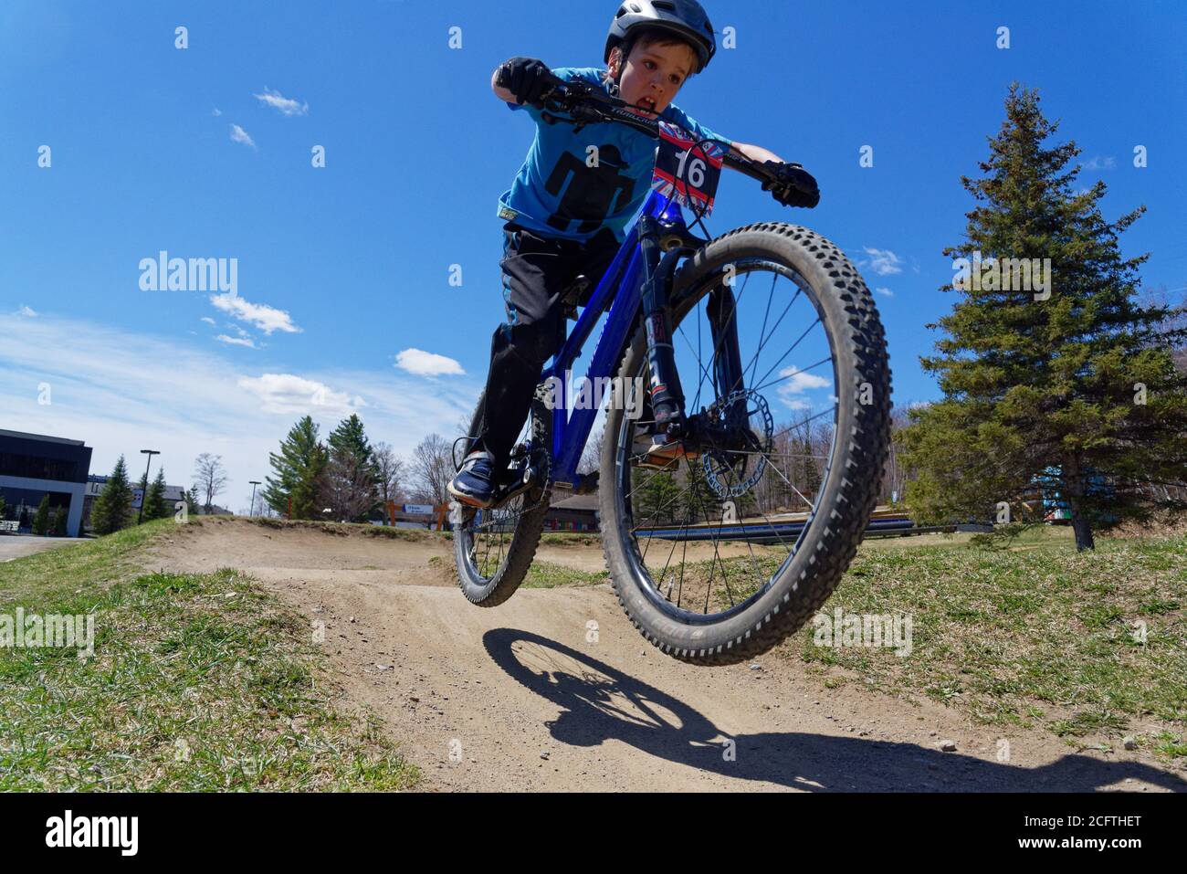 A young boy (8 yrs old) jumping on his mountain bike Stock Photo