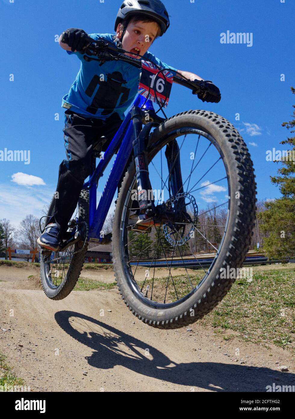 A young boy (8 yrs old) jumping on his mountain bike Stock Photo