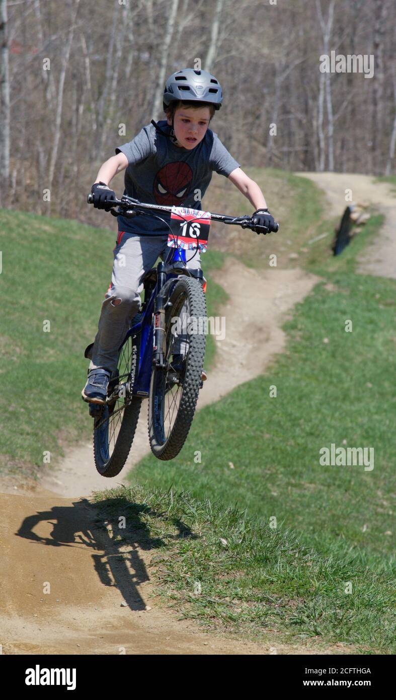 A young boy (8 yrs old) jumping on his mountain bike Stock Photo