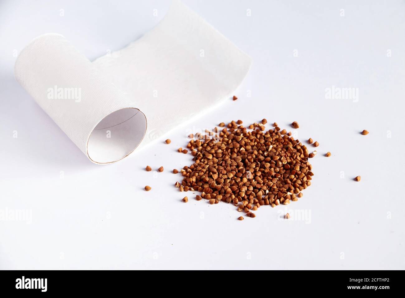 Toilet paper and buckwheat on a white background. Concept panic buying food at a quarantine. The coronavirus epidemic. Stock Photo