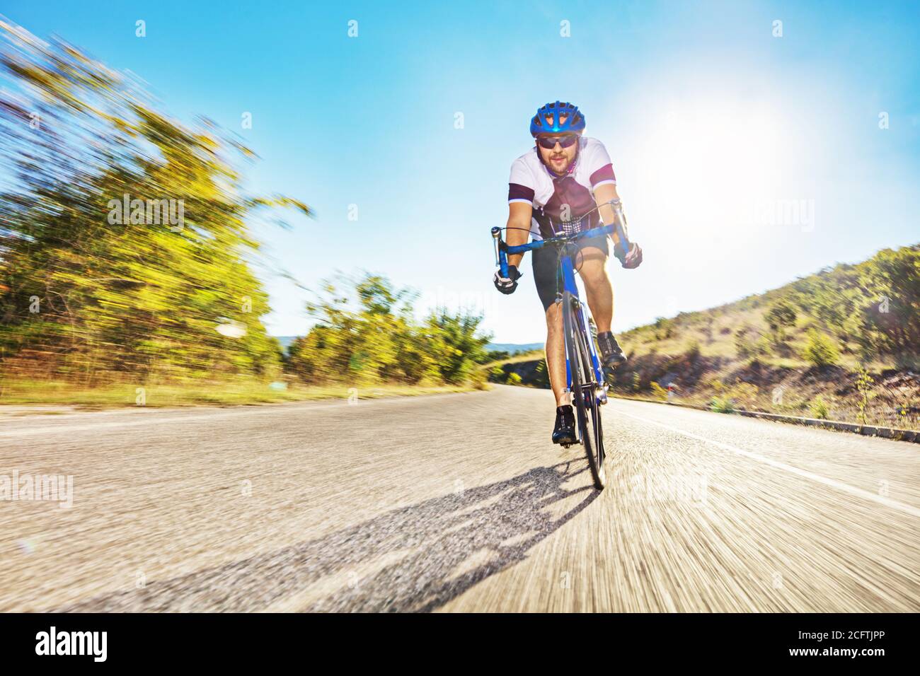 Male bicyclist riding on an open road Stock Photo