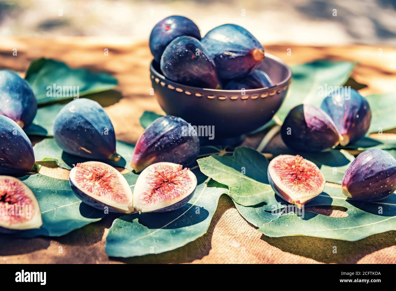Few figs in a bowl and on the fig leaves Stock Photo