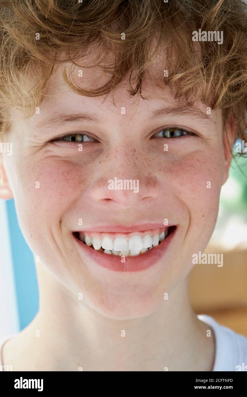 close-up portrait of redhead smiling boy with freckles, teen boy has perfect toothy smile Stock Photo