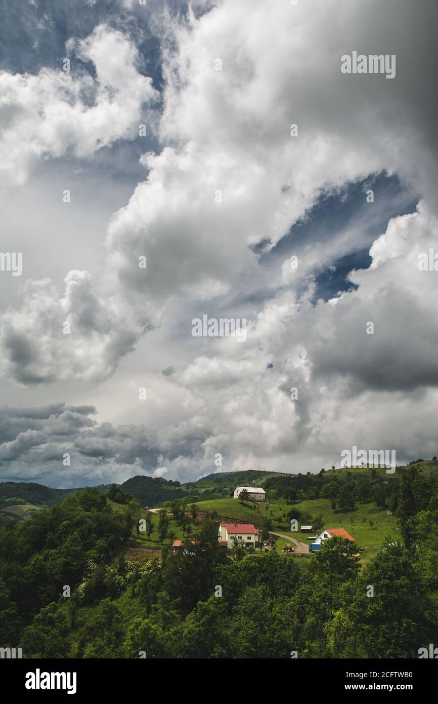 Beautiful shot of houses in a green mountain landscape on a cloudy sky ...