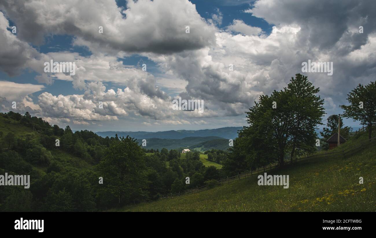 Beautiful shot of a house in a green mountain landscape on a cloudy sky ...