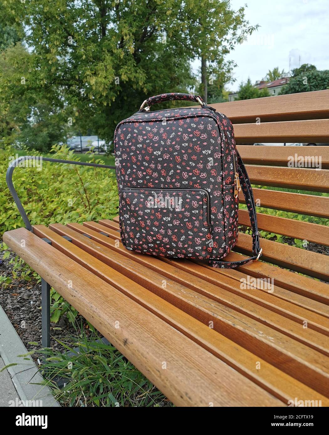 Lost backpack on the bench. The woman lost her backpack on a wooden bench. Stock Photo