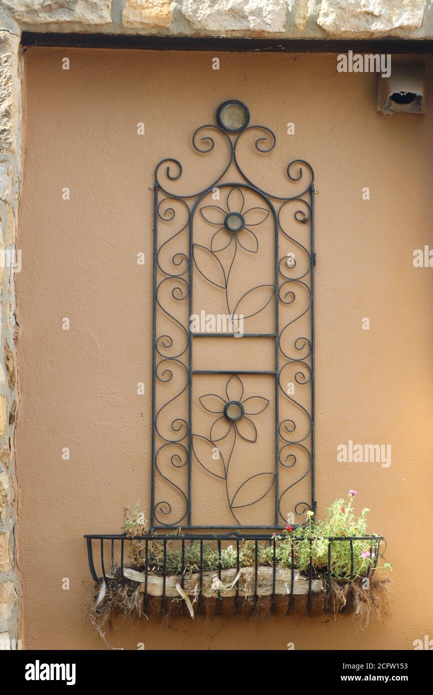 The flowers are displayed on the metal planter on the wall. Stock Photo