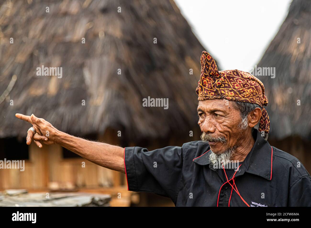 A ring glints on the outstretched index finger of the village chief of a mountain village near Moni, Flores, Indonesia, as he speaks to visitors in profile. Stock Photo