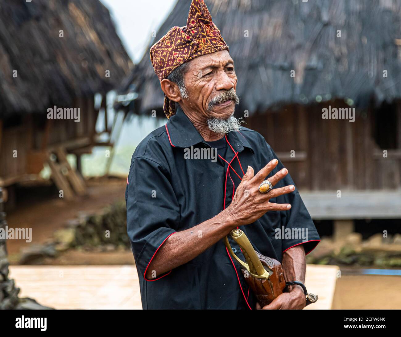 The village chief places his hand, wearing a large ring, against his chest as he addresses the visitors, mountain village near Moni, Flores, Indonesia. Stock Photo