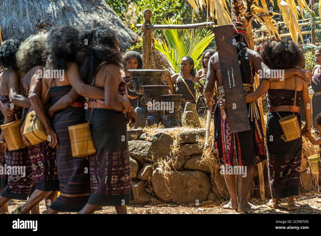 Dancers link arms and move in a circle during the Lego-Lego dance, woven bamboo pouches hanging at their hips, in the village of Takpala, Alor, Indonesia. Stock Photo