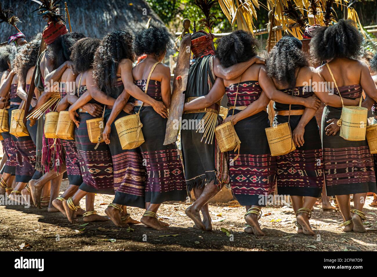 A man among the line of dancers carries a flat wooden board during the Lego-Lego dance in the village of Takpala, Alor, Indonesia. Stock Photo