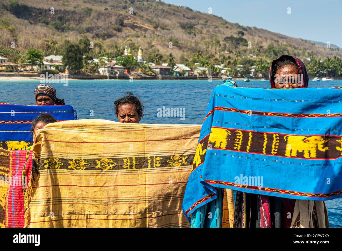 Indonesian sellers offer their textiles from boat, Sunda Islands