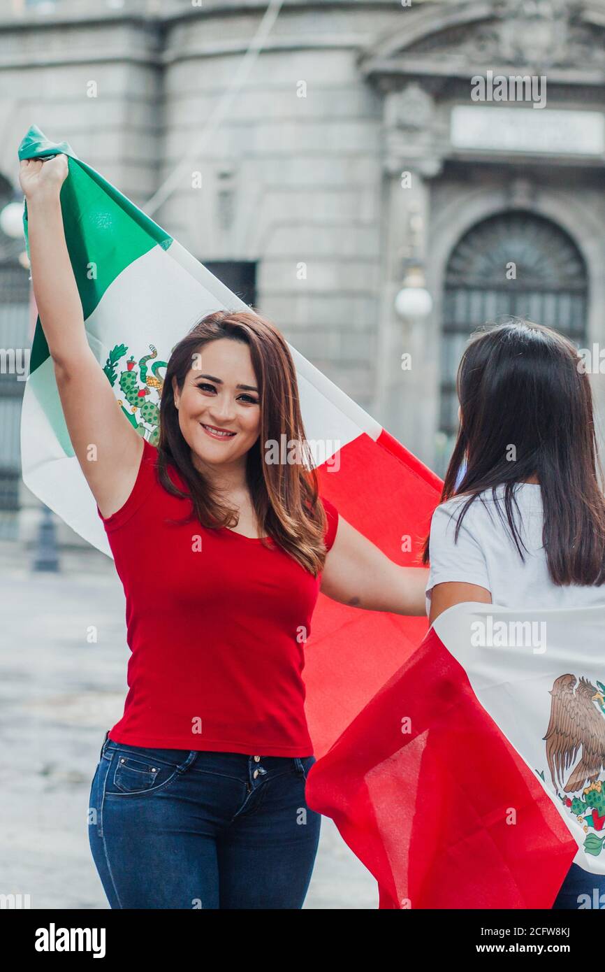 mexican girls friends at independence day in Mexico holding a flag of mexico  Stock Photo - Alamy