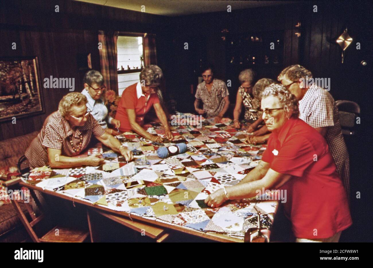 Women work at finishing a quilt with their group in New Ulm, MN in the