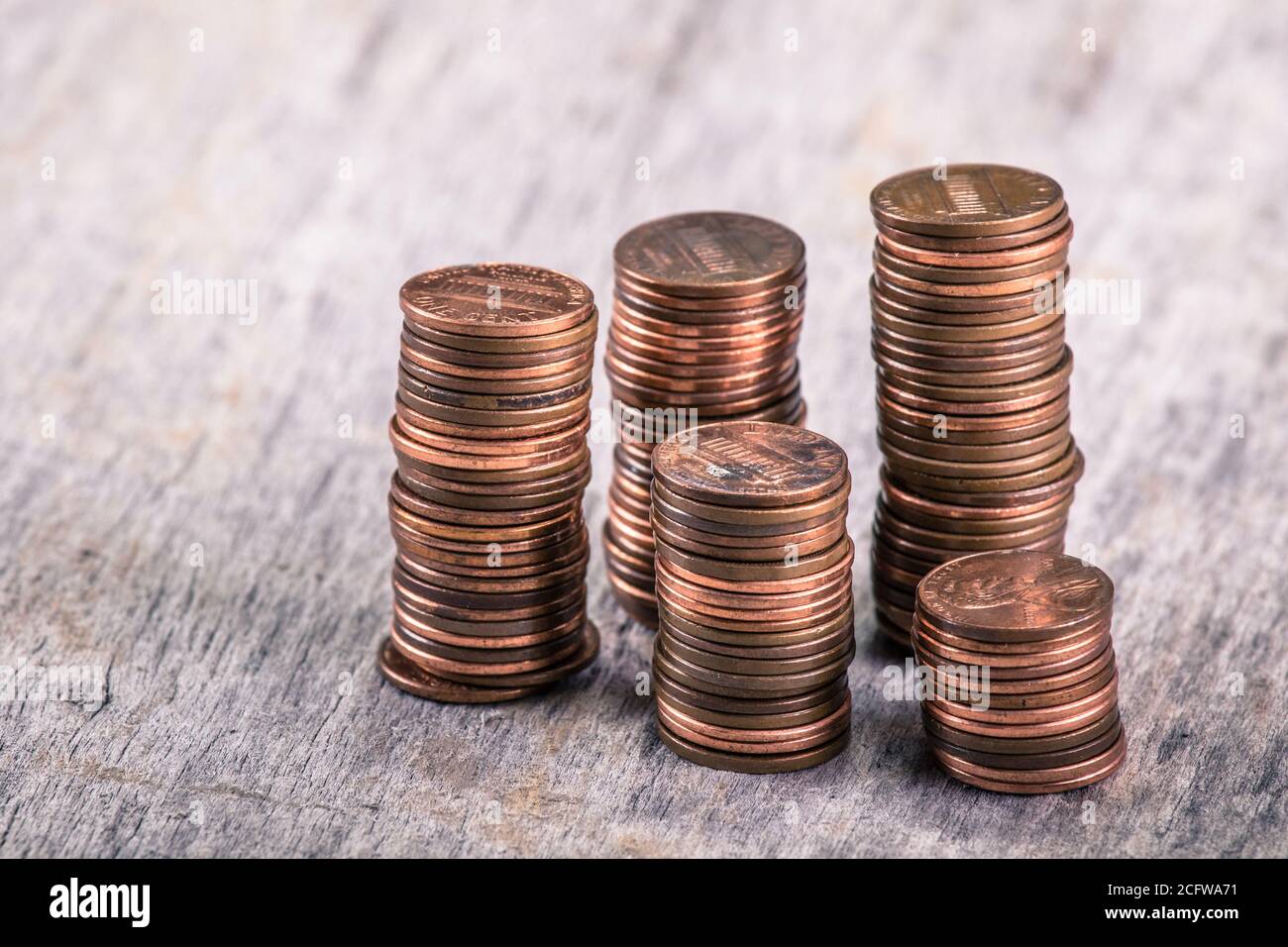 Stacks of old pennies on a wooden table Stock Photo