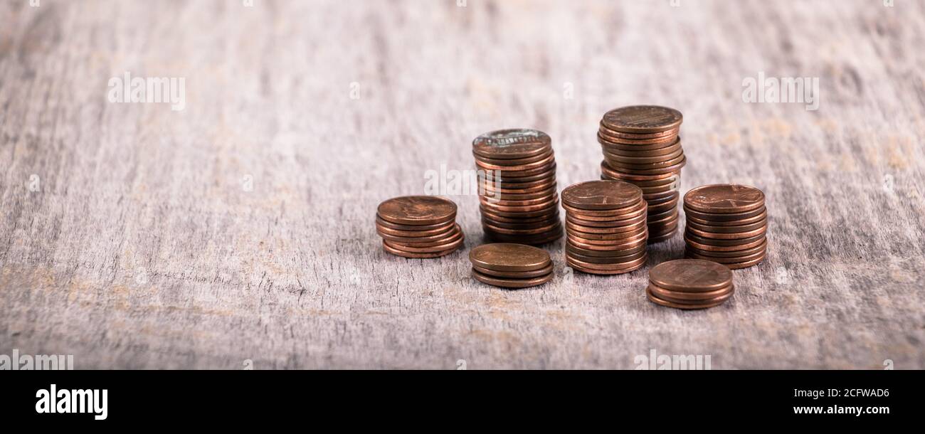 Stacks of old pennies on a wooden table Stock Photo