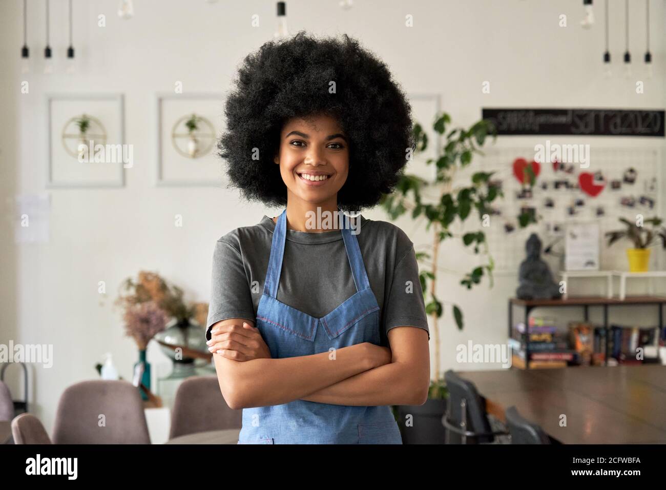 Happy African young woman cafe small business owner standing arms crossed. Stock Photo
